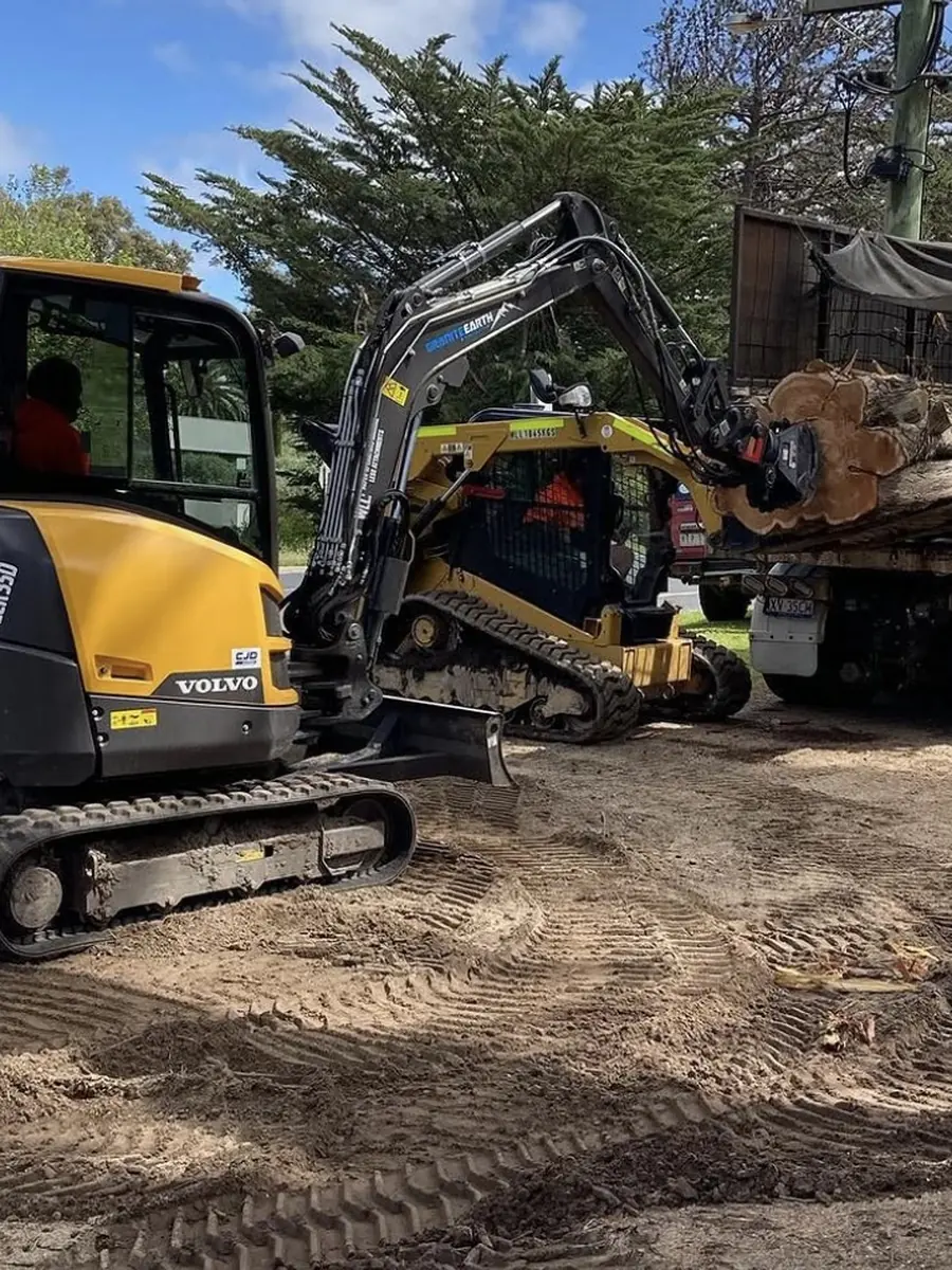 Tracked excavator loading a tipper truck on a roadside job