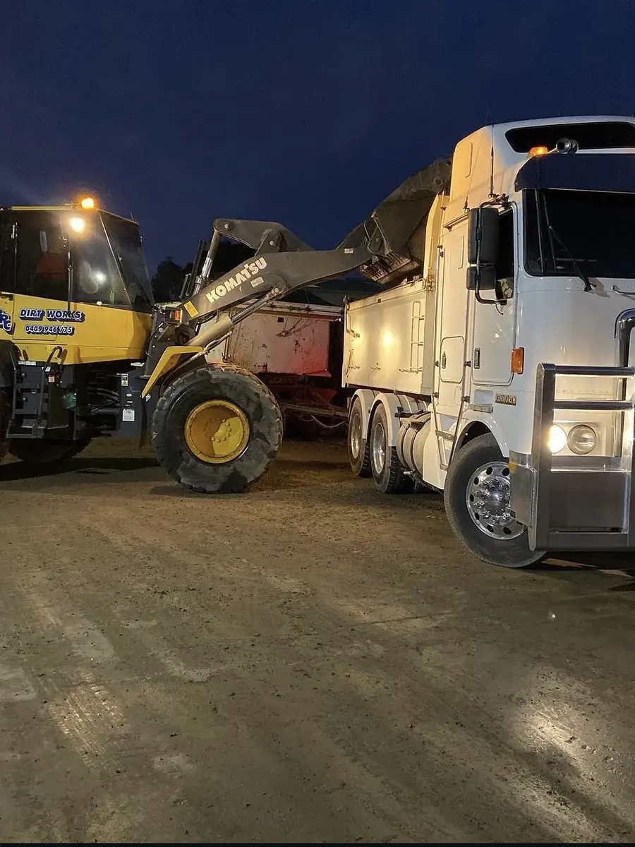 Wheel loader loading a tipper truck under lights